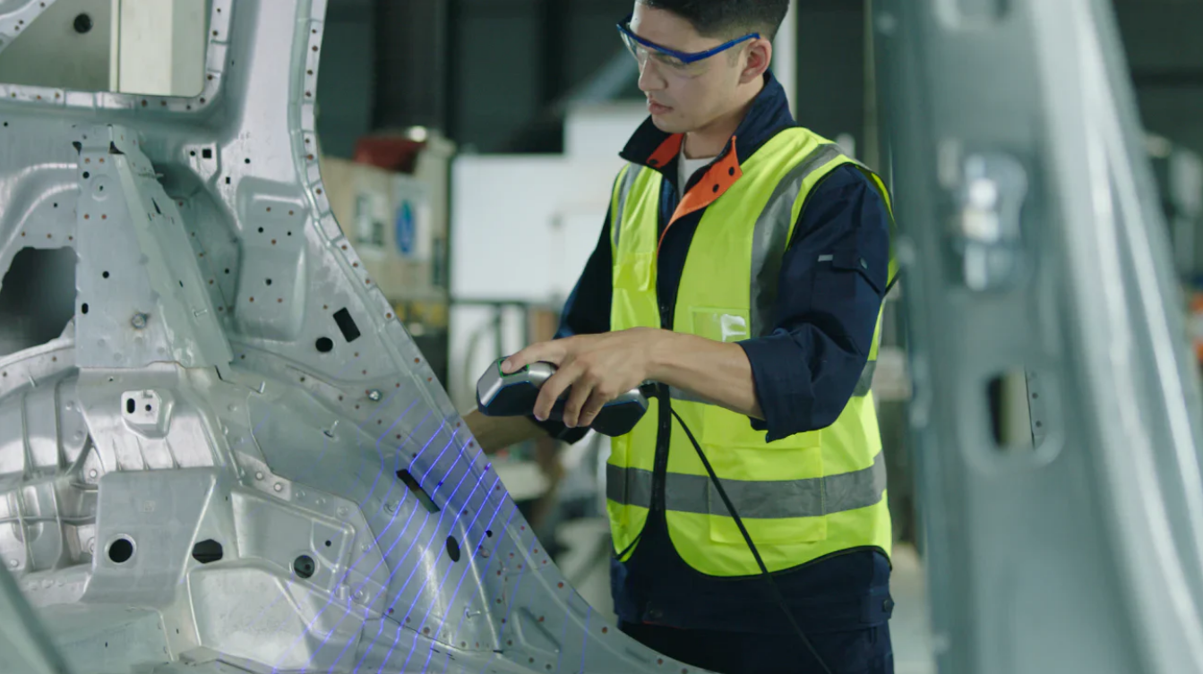 Scanner 3D Revopoint MetroX escaneando com laser azul a carroceria metálica de um carro